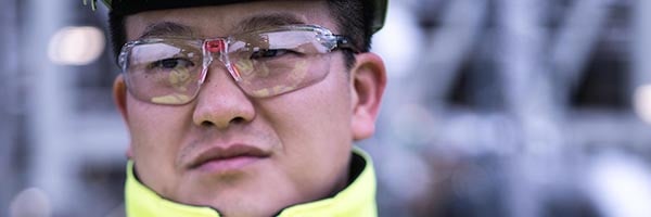 Close up of male Asian engieer wearing hard hat and safety glasses
