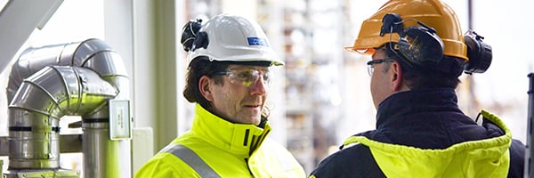 Workers discussing at oil refinery