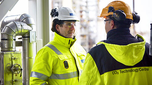 workers discussing at oil refinery